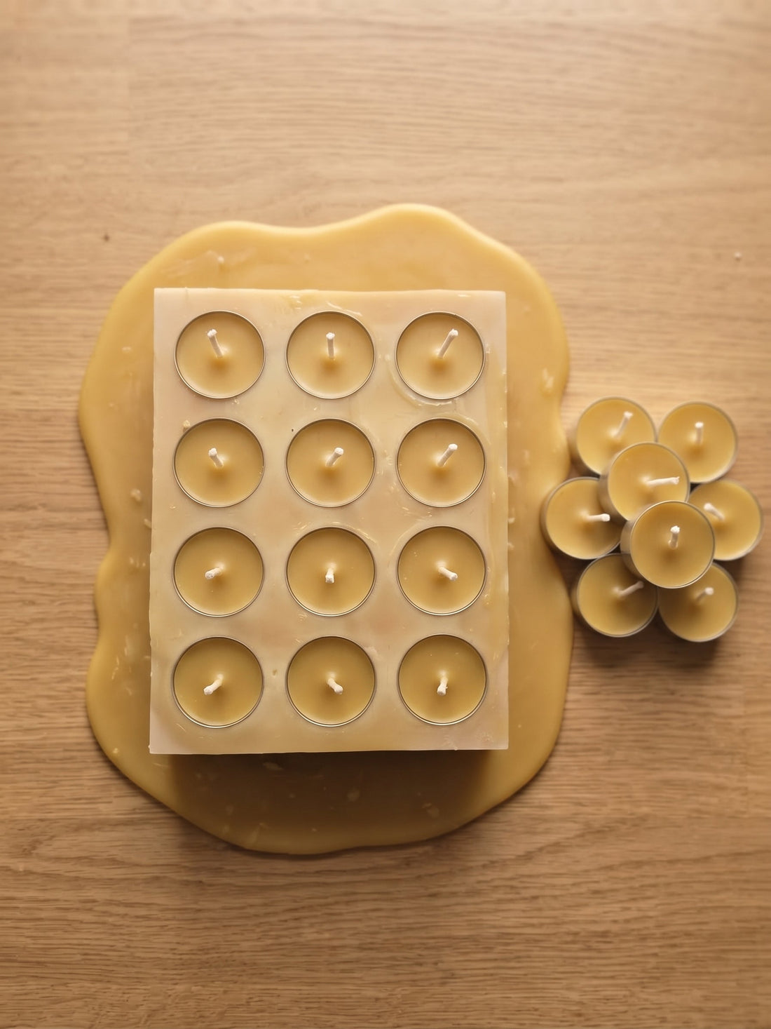 Die handgefertigten Bienenwachs-Teelichter befinden sich noch in ihrer flexiblen Silikonform, bevor sie vollständig herausgelöst werden.