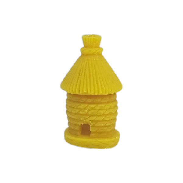 Eine kleine, detailreiche Bienenwachskerze in Form eines traditionellen Bienenstocks (Bienenkorb) mit Strohdach und einem kleinen Eingang unten vor weißem Hintergrund.